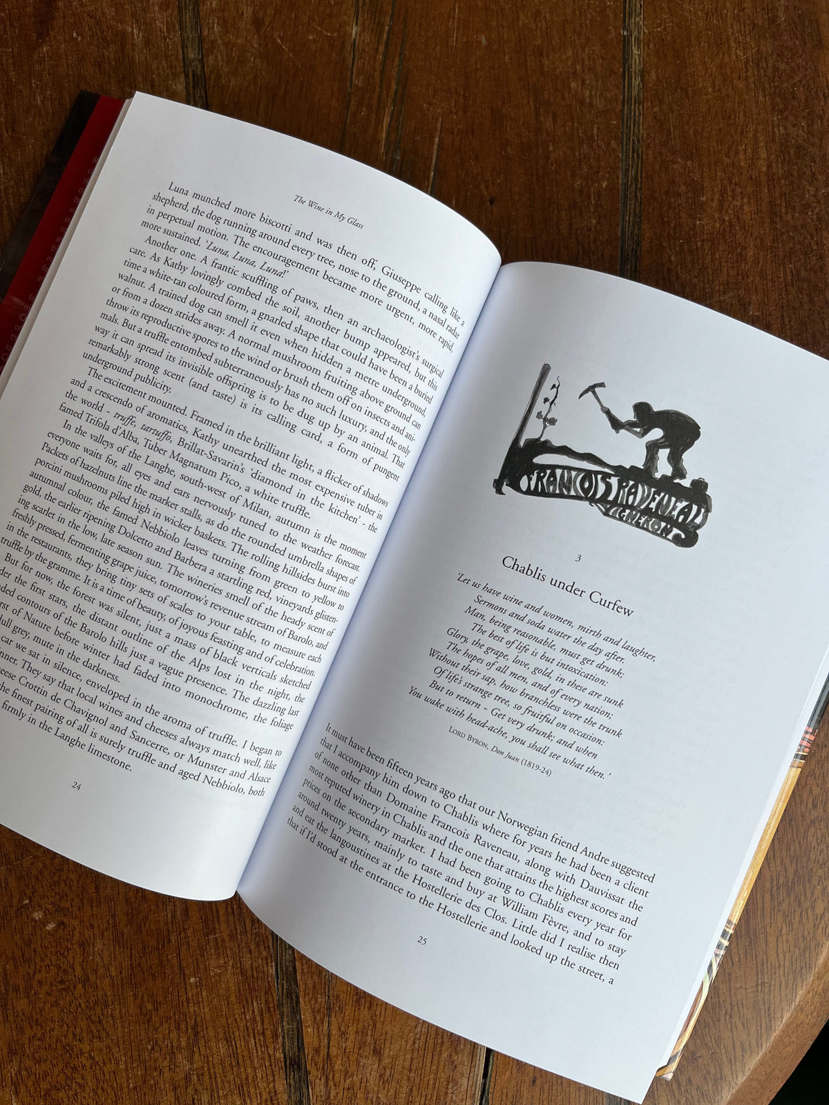 Open book with text and a black and white illustration on a wooden surface